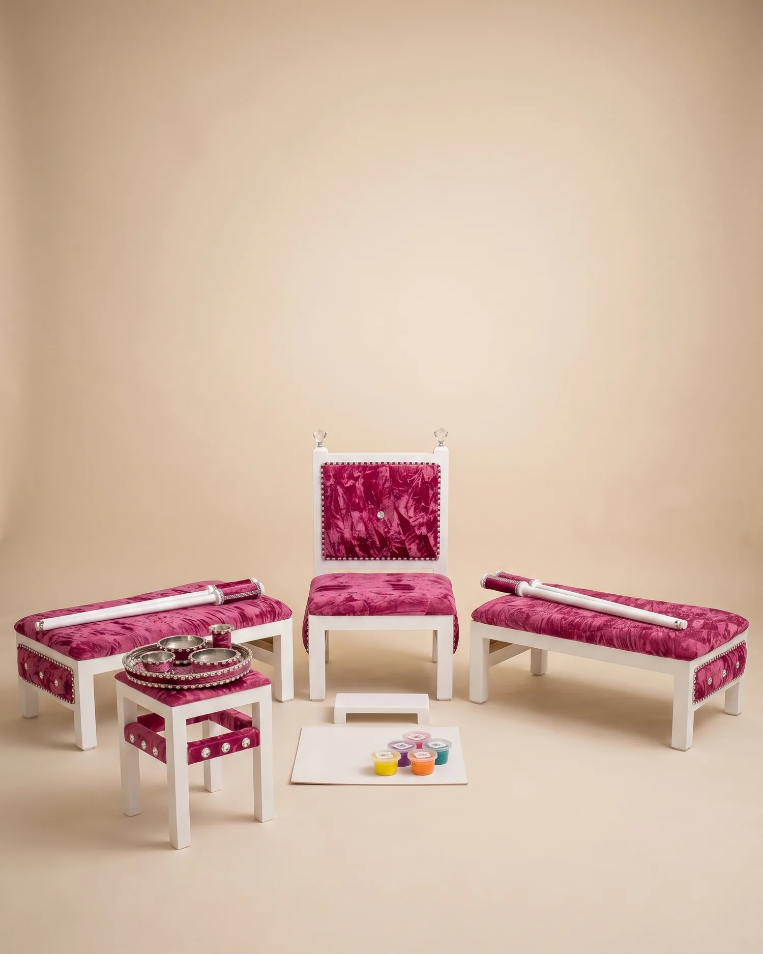 The Rose Quartz Maiyan suite on a warm ivory studio backdrop: white frames with faceted crystal finials and magenta-rose crushed velvet seats, flanked by two benches, with the tray table and rhinestone Sagan tray alongside.