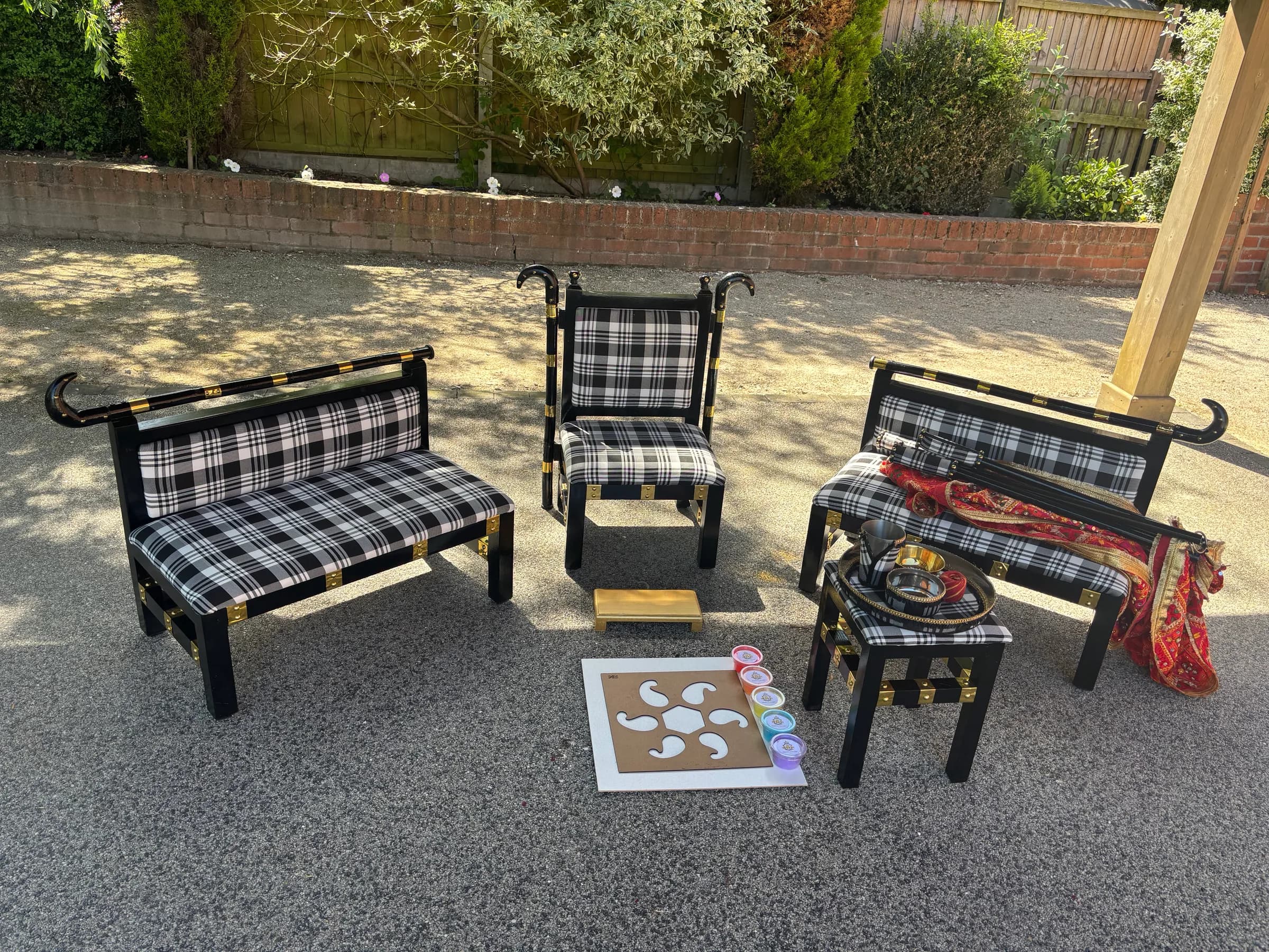The Gabru suite set up outdoors on a paved driveway for a Maiyan, with a rangoli board laid in front of the head chair.