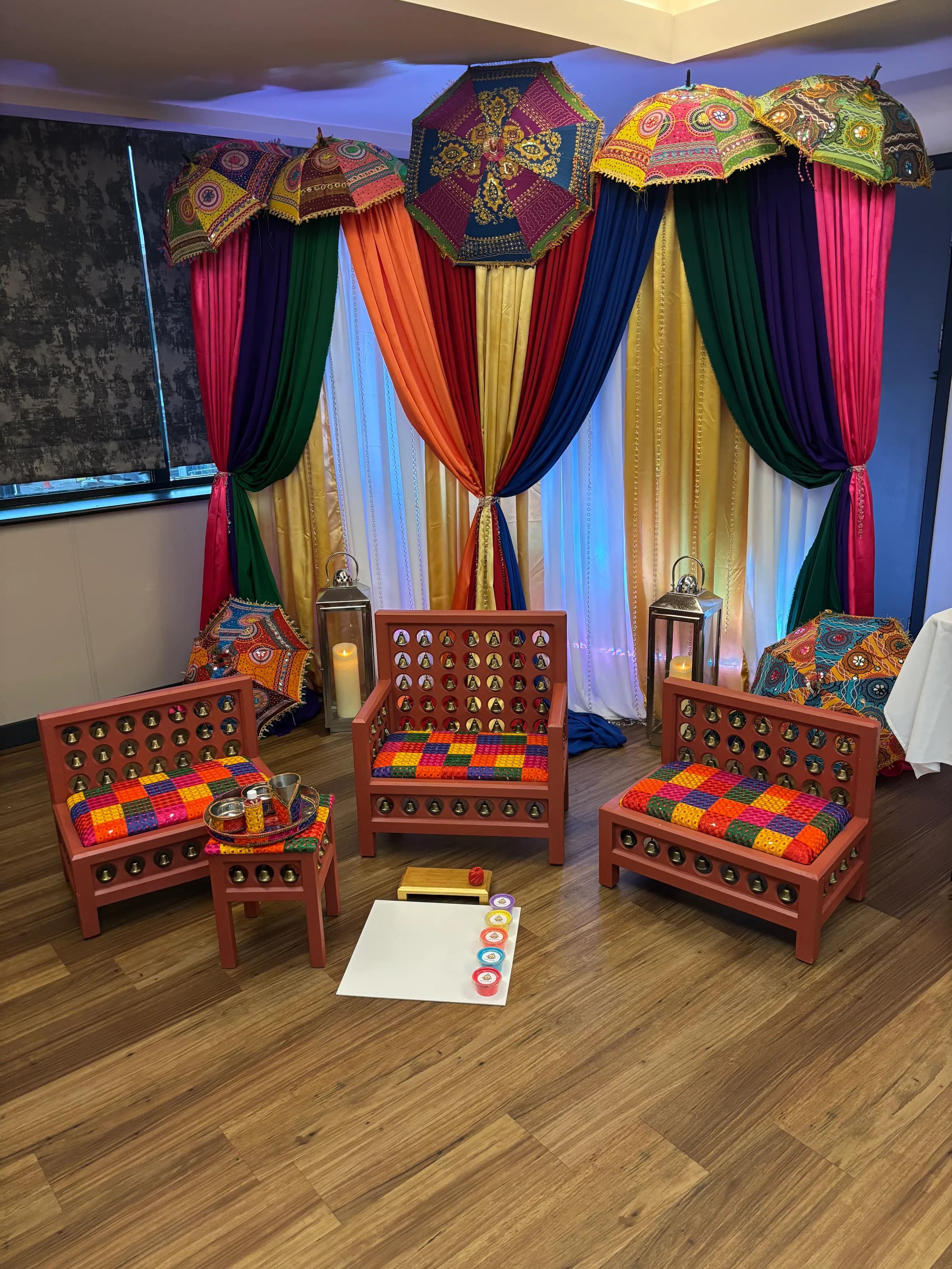 A Maiyan suite set in front of a full backdrop of rainbow drapes and embroidered parasols.