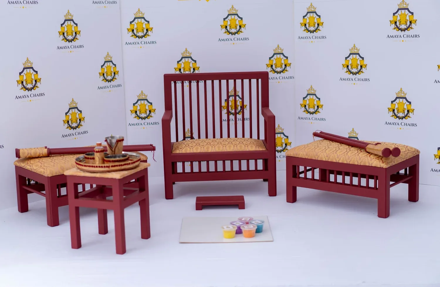 The full Peaches & Wine suite photographed in the workshop: head chair, both benches, tray table and the rangoli board laid out.