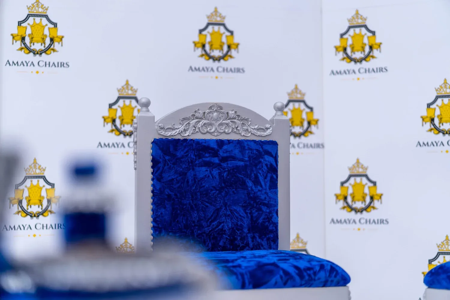 The Blue Prince head chair showing the carved silver-grey crest above royal blue crushed velvet.