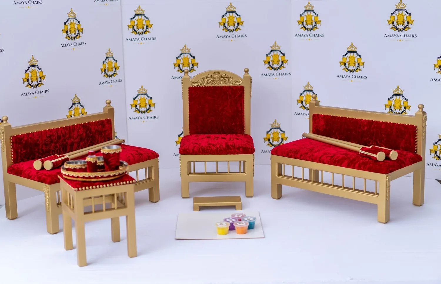 The Royal Crimson suite photographed in full: gold frames with carved crests and deep crimson crushed velvet seats.