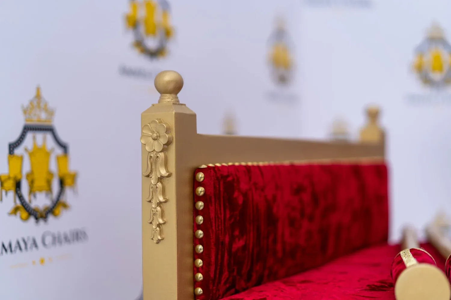 The Royal Crimson head chair showing the carved gold crest above crimson velvet upholstery.