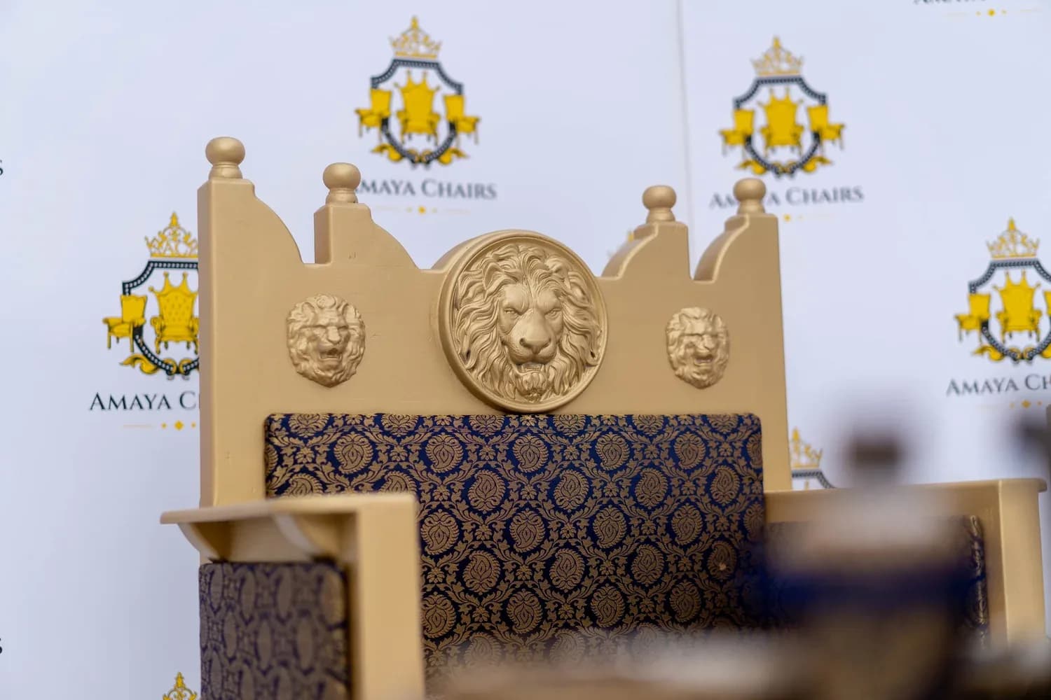 Close view of the carved lion medallion and crown-shaped crest on The Majestic Lion head chair.