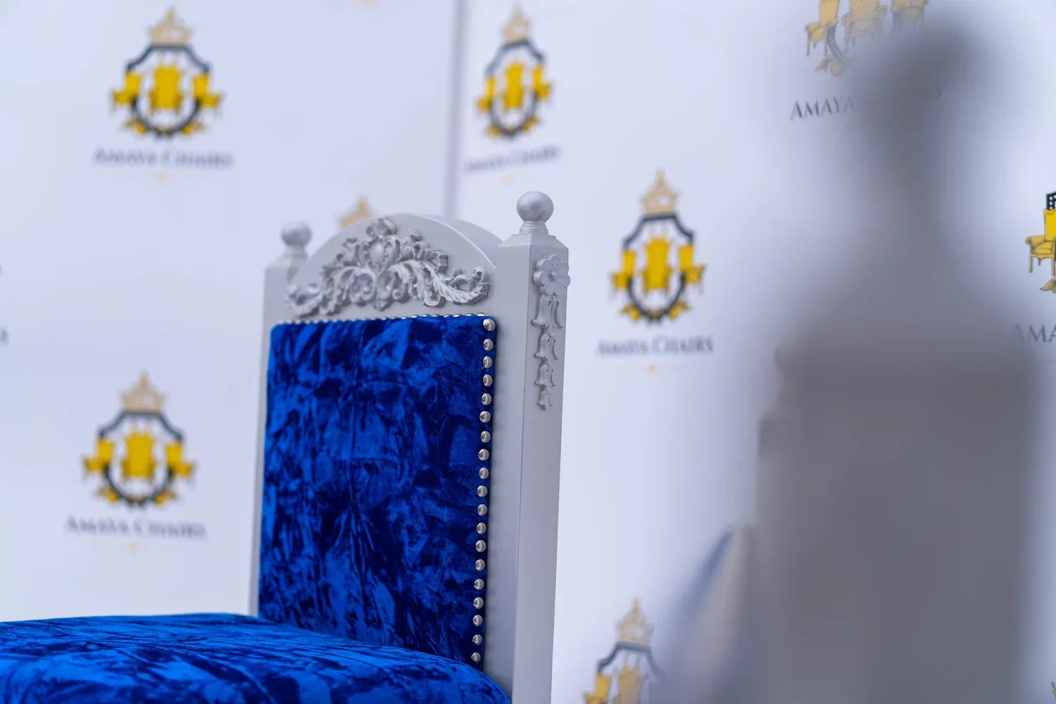 Close view of the carved silver-grey crest on The Blue Prince head chair.
