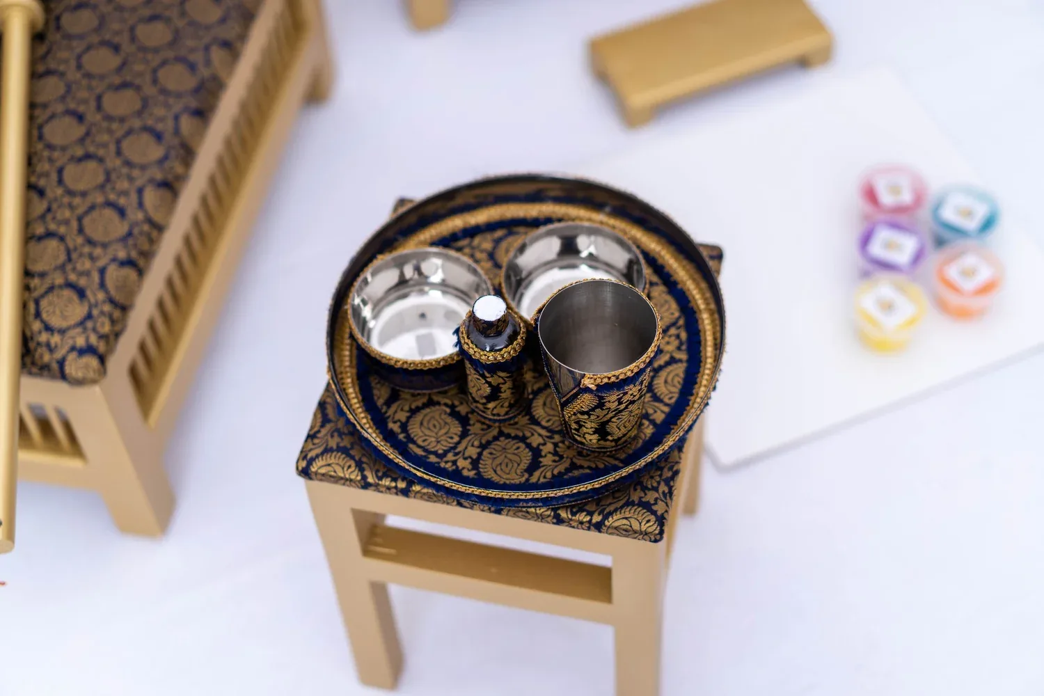 The Majestic Lion tray table with the brass Sagan tray, ceremony bowls and pots of rangoli colour.