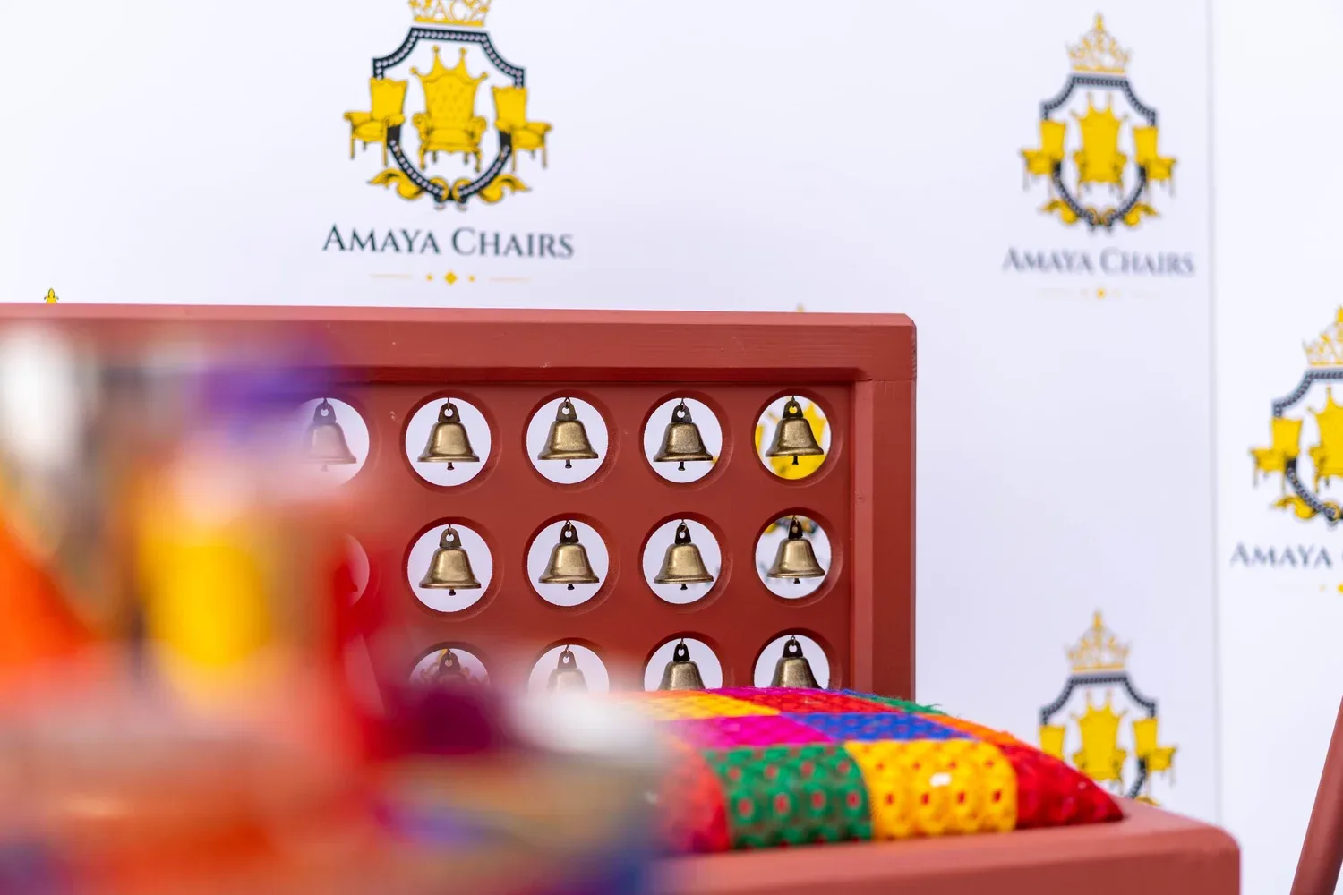 A Satrang side bench showing the phulkari-style bolster and multicoloured seat against the terracotta frame.