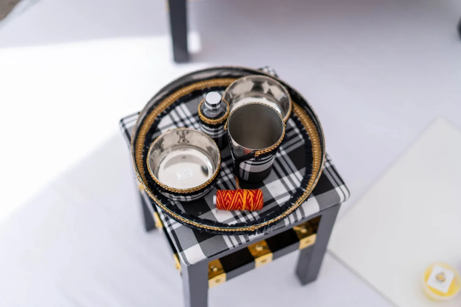 The Gabru tray table dressed for the ceremony, with the brass Sagan tray, bowls, cup and red bangles set on top.